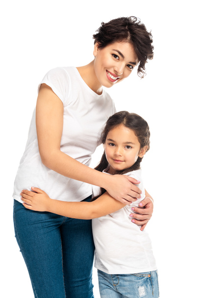 happy latin mother hugging with cute daughter isolated on white  - Photo, Image