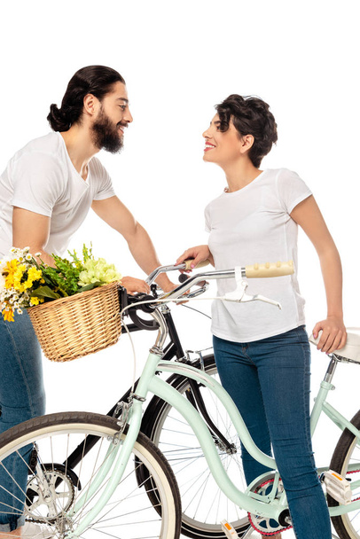 heureux latin homme regardant attrayant brunette femme tout en se tenant près de vélo isolé sur blanc
  - Photo, image