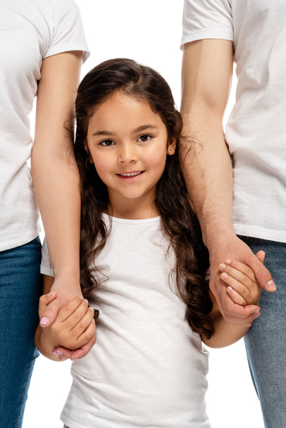 rajattu näkymä vanhempien kädestä iloinen latina tytär seisoessaan eristetty valkoinen
  - Valokuva, kuva
