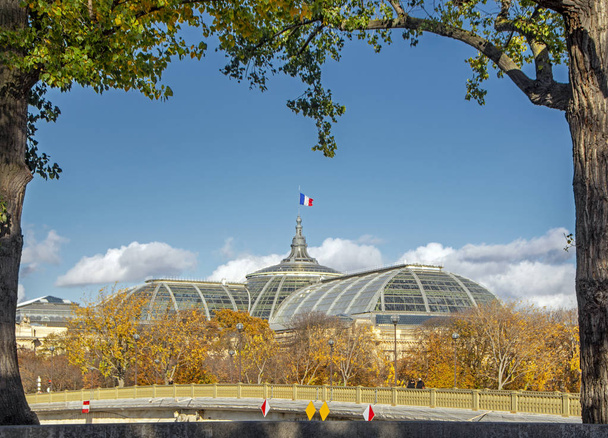 Gyönyörű jelenet a szüreti épület francia zászló rajta a természetes keretben a fák és a zöld levelek. Ősz Párizsban, Franciaország - Fotó, kép