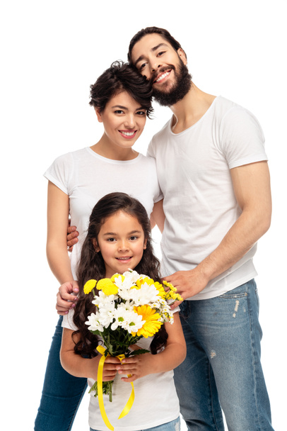 latin parents smiling near cute daughter holding flowers isolated on white  - Photo, Image