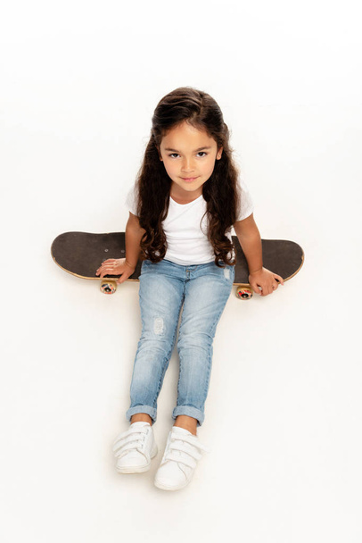 vue aérienne de mignon latin enfant assis sur penny conseil isolé sur blanc
  - Photo, image