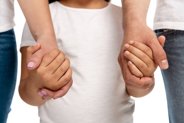 oříznutý pohled rodičů držící ruce s dcerou izolovanou na bílém  - Fotografie, Obrázek