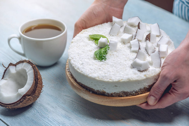 Pastel de coco crudo decorado con pulpa blanca y menta. Postres veganos frescos saludables. Alimentos sin gluten y sin azúcar
 - Foto, imagen