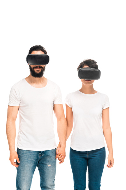 latinsky muž a žena nosí sluchátka s virtuálními realitou a drží ruce při stání na bílém  - Fotografie, Obrázek