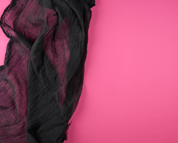 black textile gauze on a pink background - Фото, изображение