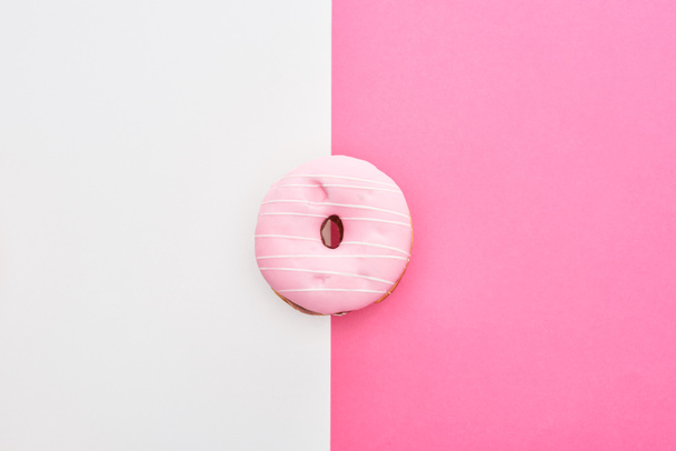 top view of glazed pink doughnut on white and pink background  - Foto, afbeelding