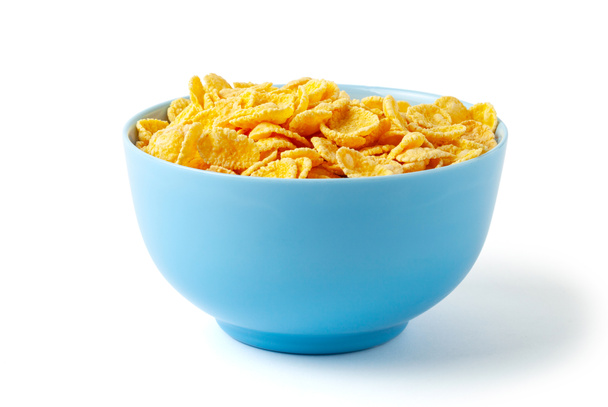 Trockene FrühstückCornflakes. blauer Teller voller Getreide. isoliert auf weißem Hintergrund. - Foto, Bild