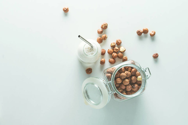 veganistische melk in glazen pot op witte achtergrond - Foto, afbeelding