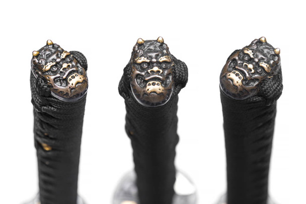 3 vistas de Kashira: tope (o pomo) hecho de cobre en el extremo de la empuñadura del cordón de seda negro Espada japonesa aislada en fondo blanco. Estilo de cara diabólica
. - Foto, Imagen
