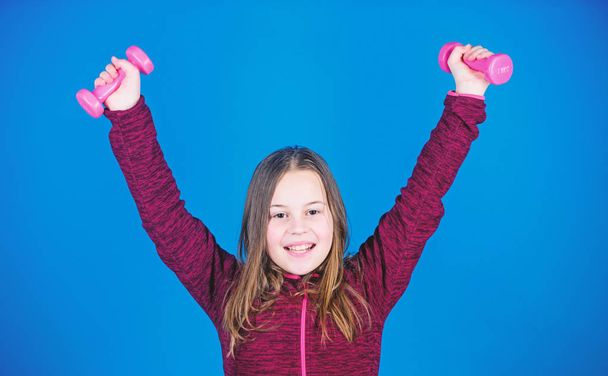 weight lifting for muscules. Childhood activity. Happy athletic child with barbell. workout of athletic small girl hold dumbbell. Fitness diet for energy health. Sport success. athletic training - Valokuva, kuva