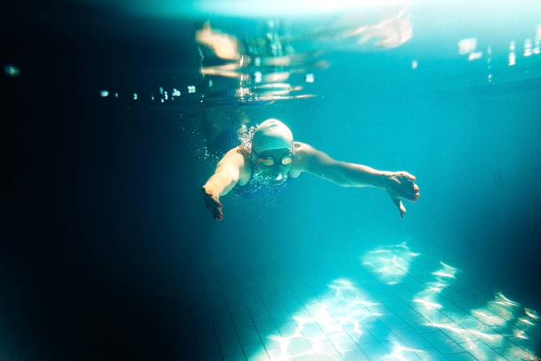 Θηλυκό κολυμβητής σε πισίνα. Υποβρύχια φωτογραφία. - Φωτογραφία, εικόνα