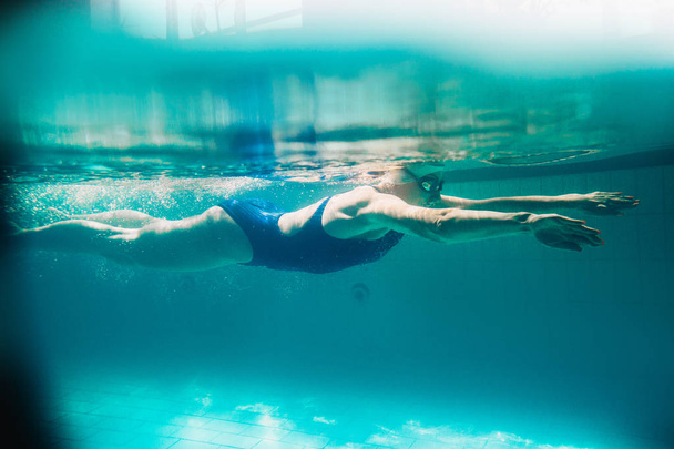 Женщина пловчиха у бассейна. Подводное фото
. - Фото, изображение