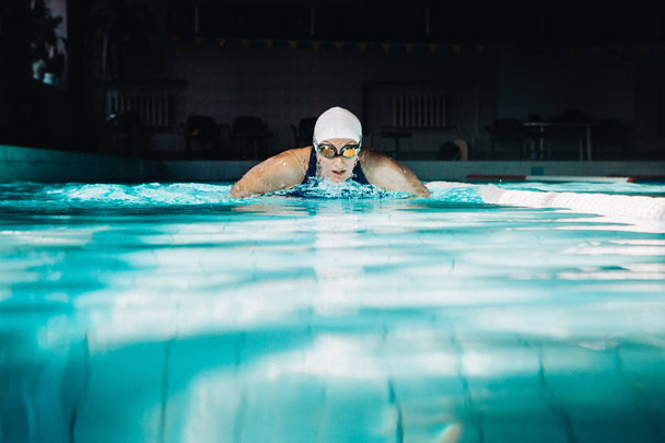 Профессиональная женщина плавает с использованием техники брасса на
  - Фото, изображение