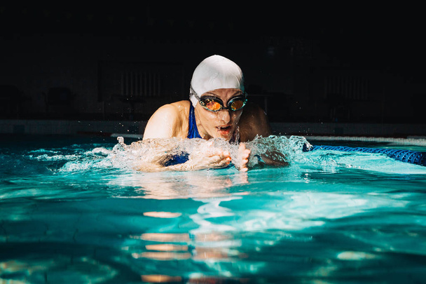 Profi-Schwimmerin schwimmt mit Brustschwimmtechnik auf  - Foto, Bild