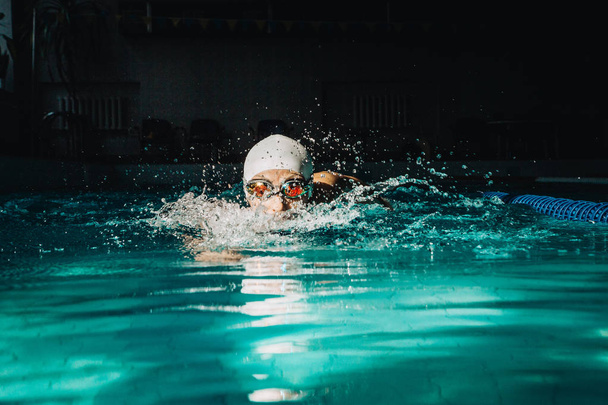 Ammattimainen nainen uimari uida käyttäen rintahalvaus tekniikka
  - Valokuva, kuva