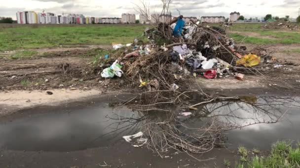ein Müllhaufen auf dem Hintergrund von Häusern. Umweltverschmutzung. - Filmmaterial, Video