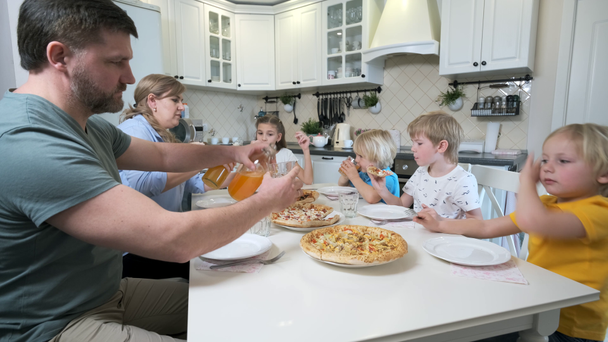 Family with children eating pizza at the table - Séquence, vidéo