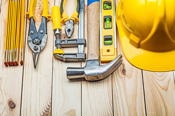 yellow helmet and construction tools on wooden boards - Фото, изображение