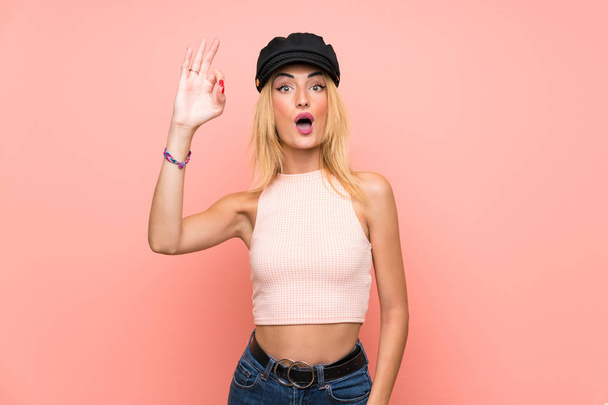 Mujer rubia joven con sombrero sorprendido y mostrando signo ok
 - Foto, imagen