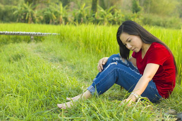 Teen girl Asian sitting in rice field thinking and smiling happi - Фото, зображення