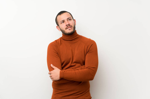 Homem colombiano com suéter de gola alta com expressão facial confusa
 - Foto, Imagem