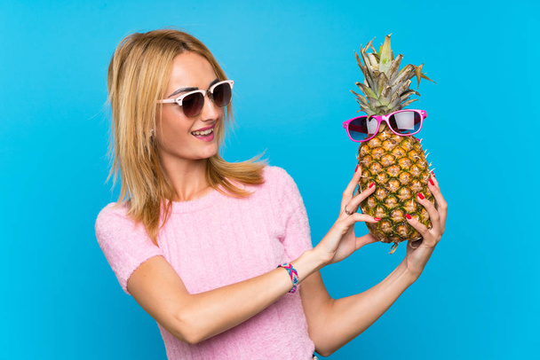 Jeune femme tenant un ananas avec des lunettes de soleil
 - Photo, image