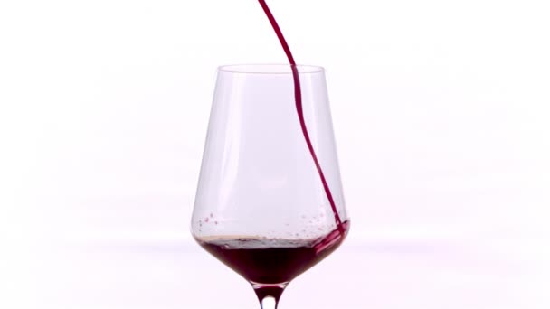 Czerwone wino nalewanie w szklance na białym tle, w zwolnionym tempie - Materiał filmowy, wideo
