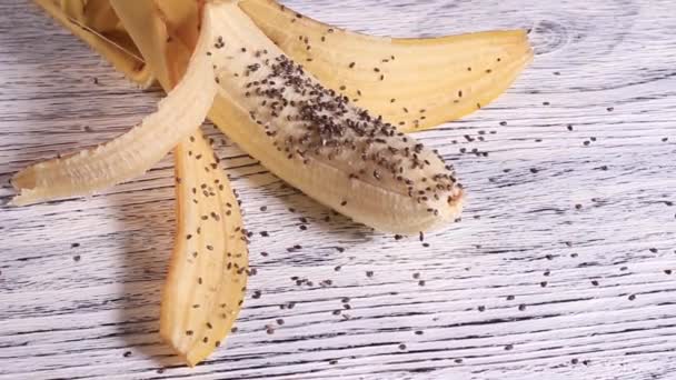 Chia seeds piled on peeled banana - Záběry, video
