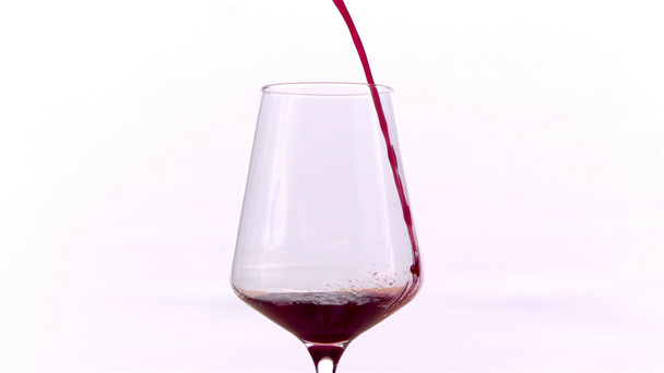 Czerwone wino nalewanie w szklance na białym tle, w zwolnionym tempie - Materiał filmowy, wideo