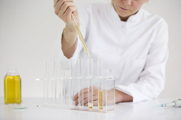 Wissenschaftler bei der Überprüfung eines pharmazeutischen cbd-Öls in einem Labor mit Glastropfen und Röhrchen - Foto, Bild