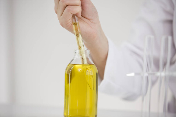 Ученый, работающий с фармацевтическим маслом CBD в лаборатории со стеклоочистителем и миской
 - Фото, изображение