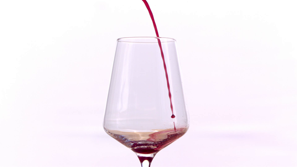 Κόκκινο κρασί που χύνεται σε γυαλί σε λευκό φόντο, αργή κίνηση - Πλάνα, βίντεο