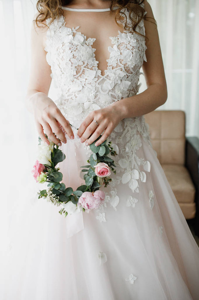 Beautiful wreath of flowers in the hands of the bride. - Фото, зображення