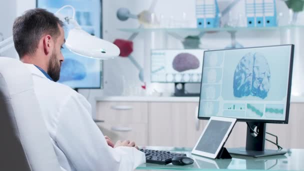 In modern research facility doctor is looking at X ray scans - Video, Çekim