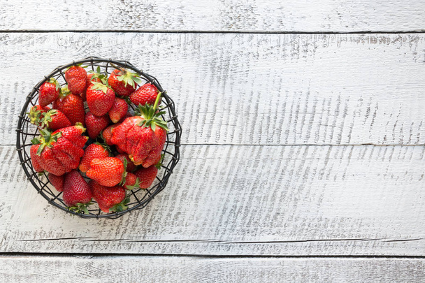 Ripe organic strawberry in vintage vase on white wooden backgrou - Valokuva, kuva