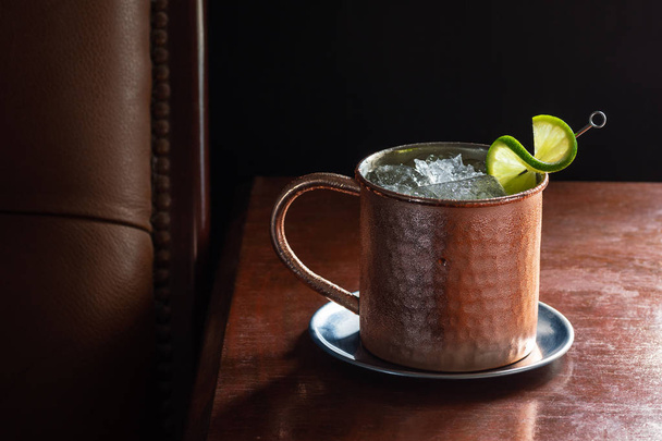 Cold Moscow Mule with Vodka and Ginger Beer in Copper Mug in Dark Luxurious Bar with Copy Space - Valokuva, kuva