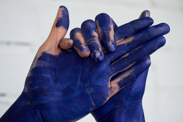 Hands in blue paint, the hands of the artist and creative person.Yoga for the hands. - Foto, Bild