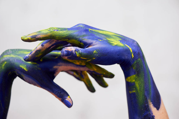 Hands in blue paint with yellow accents, hands of the artist and creative person.Yoga for hands - Fotografie, Obrázek