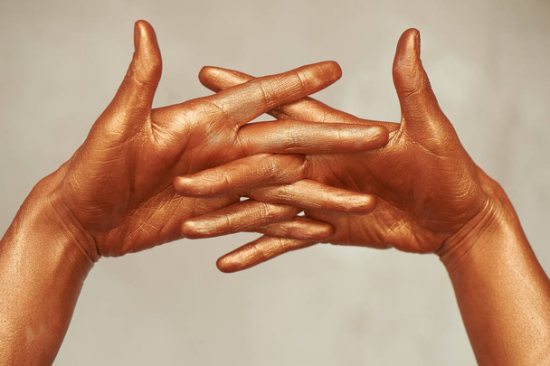 Hands in gold paint, the hands of the artist and creative person.Yoga for hands - Фото, зображення