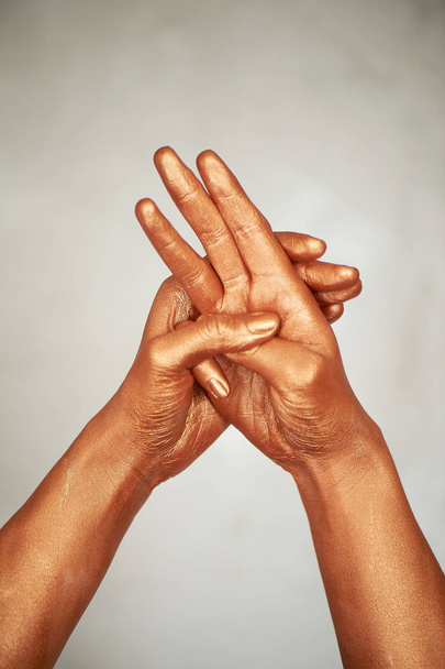 Hands in gold paint, the hands of the artist and creative person.Yoga for hands - Fotó, kép