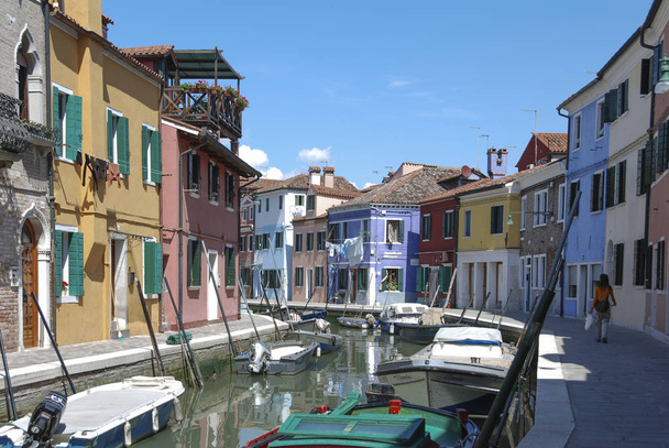 BURANO - ITALIA, 18 DE ABRIL DE 2009: Vistas panorámicas de edificios coloridos, personas no identificadas y barcos frente a un canal en Burano, Italia
 - Foto, imagen