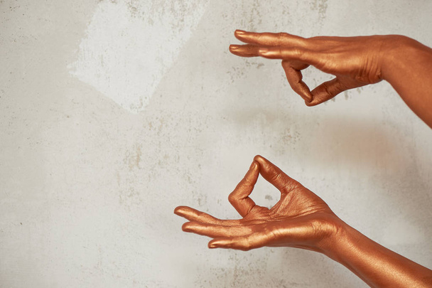 Hands in gold paint, the hands of the artist and creative person.Yoga for hands - Photo, image