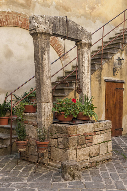 SAN QUIRICO D'ORCIA, ITALY - OCTOBER 30, 2016 - Picturesque traditional Italian courtyard in the center of San Quirico d'Orcia, Val d'Orcia, Tuscany - Foto, afbeelding