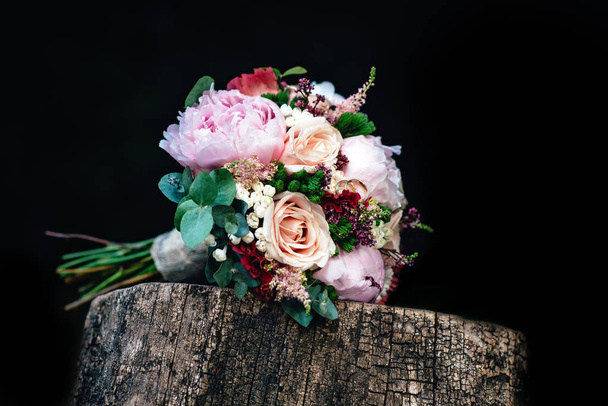 Свадебный букет из роз с кольцами на деревянной скамейке
 - Фото, изображение