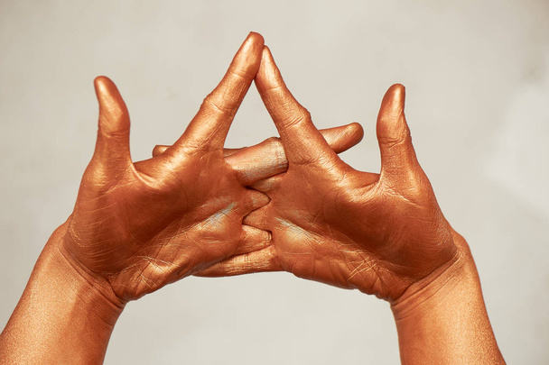 Hands in gold paint, the hands of the artist and creative person.Yoga for hands - Fotografie, Obrázek