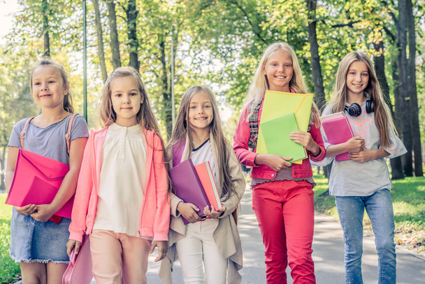 Little girls holding notebooks and folders - Фото, изображение