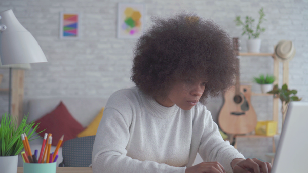Retrato mulher americana africana com um penteado afro usa um laptop em casa
 - Filmagem, Vídeo