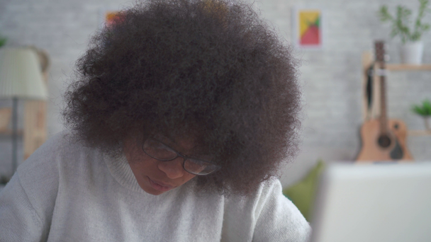Portret African American kobieta z Afro fryzura z ołówkiem w ręku - Materiał filmowy, wideo