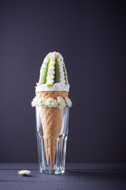 Ice cream cone and white flowers, summer concept. Ice cream with jam on black background. Waffle cone with dessert in glass. Minimalism - Fotoğraf, Görsel